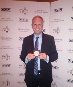 Jeremy Watkin holding Phone.com's bronze Stevie Award for Customer Service Department of the Year